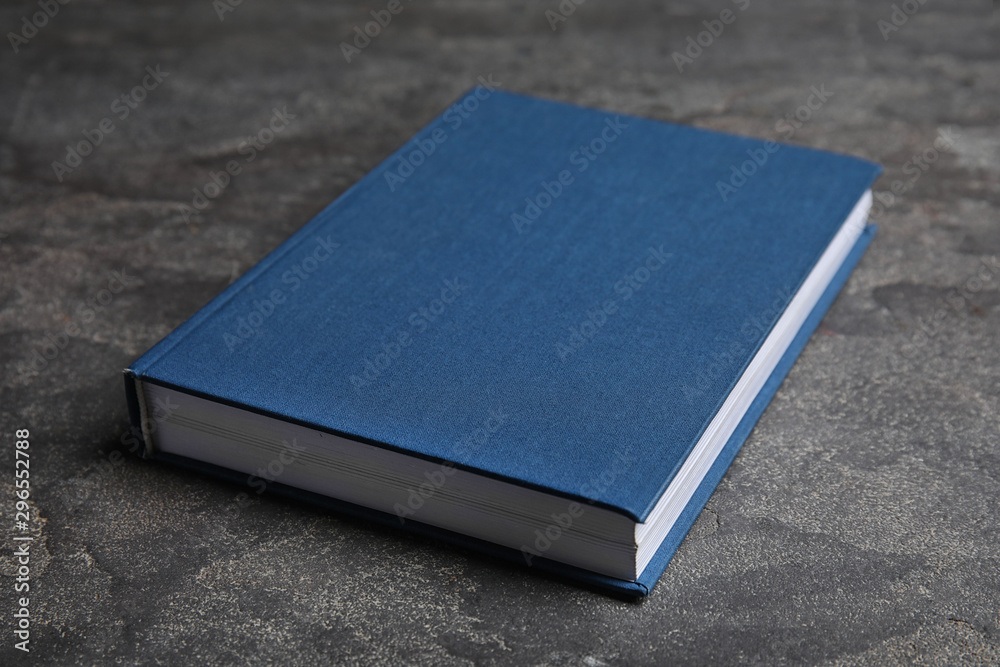 Hardcover book on grey stone table. Space for text Hardcover book on grey stone table. Space for text