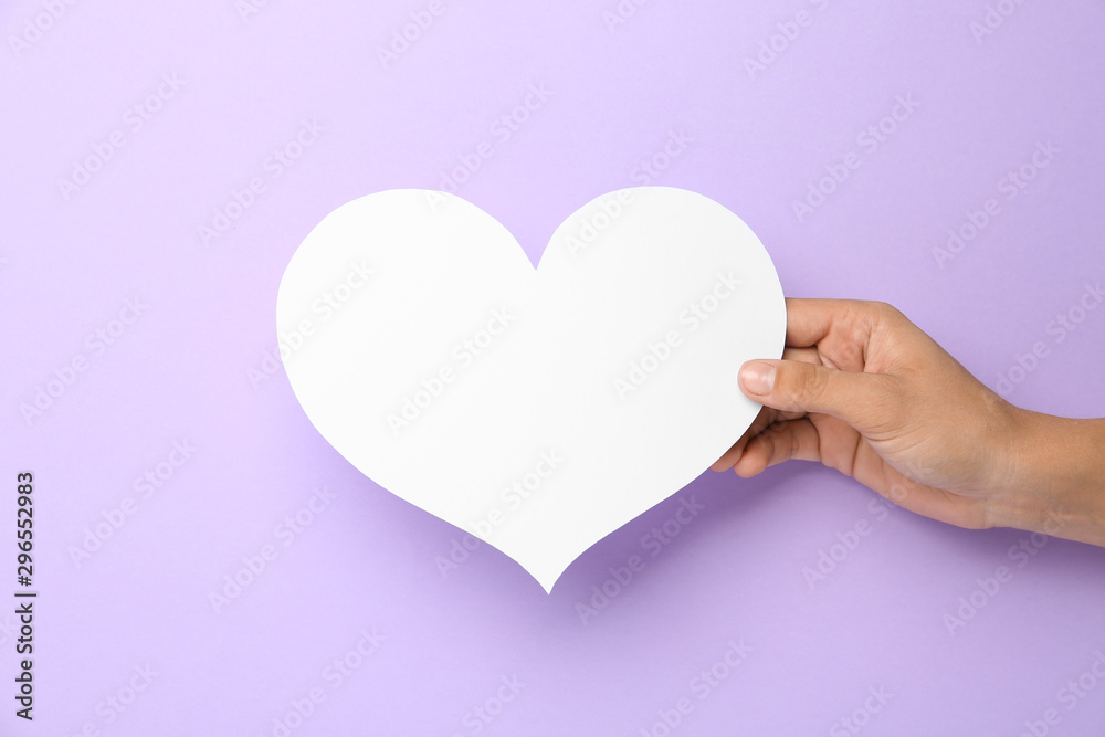 Woman holding blank paper heart on violet background, closeup. Space for text Woman holding blank paper heart on violet background, closeup. Space for text