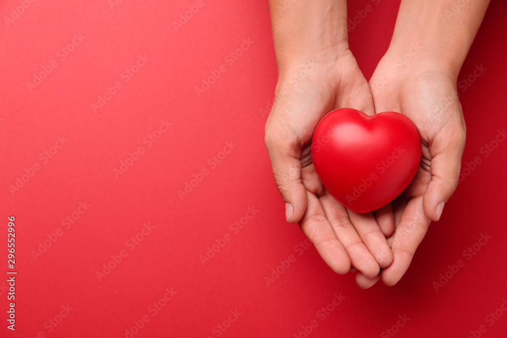 Woman holding decorative heart on red background, top view. Space for text Woman holding decorative heart on red background, top view. Space for text
