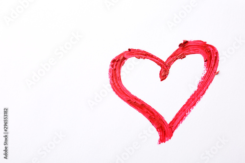 Heart drawn with red lipstick on white paper, top view