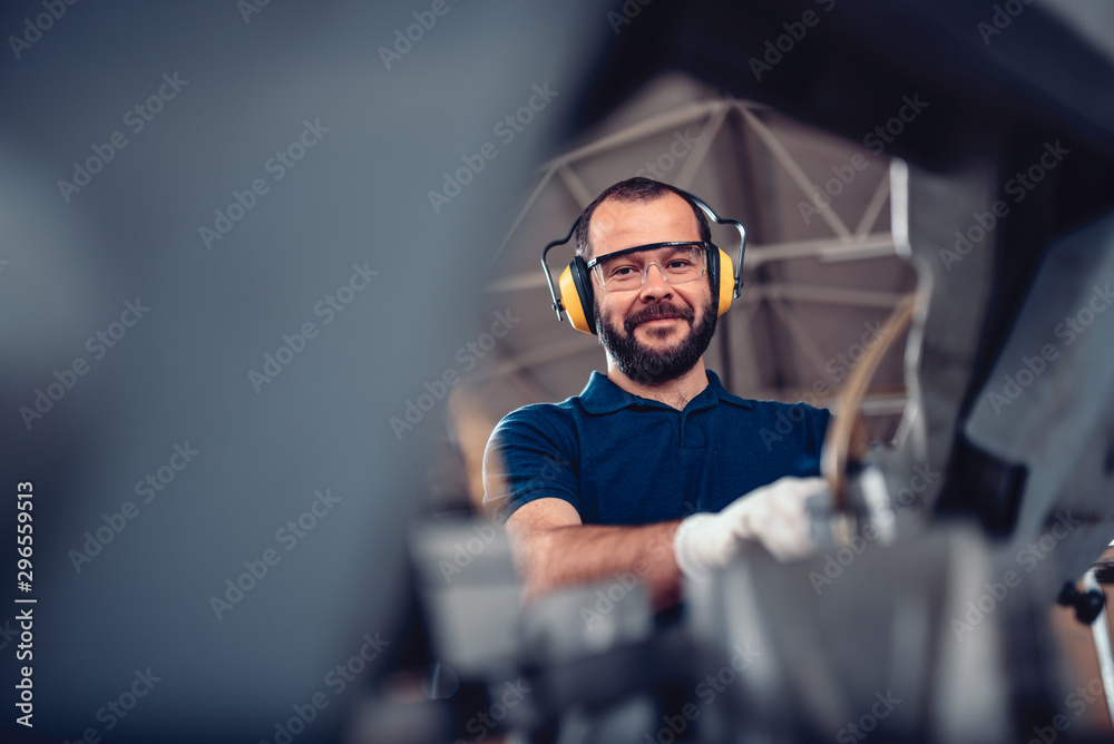 Factory worker operating band saw cutting machine Factory worker operating band saw cutting machine