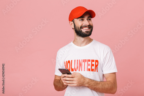 Image of joyful man volunteer smiling and holding cellphone