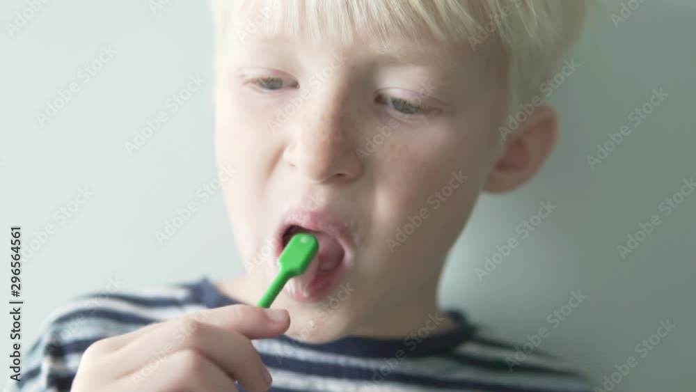Blond boy brushes teeth with toothpaste. Close-up. Morning oral hygiene Blond boy brushes teeth with toothpaste. Close-up. Morning oral hygiene
