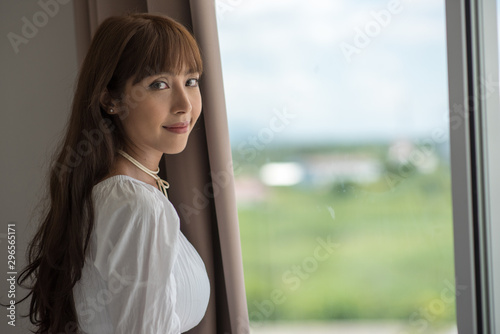 Free Download Young Woman Standing By Window At Home - GFXLoad