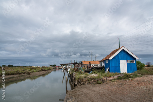 Une maison ostréicole et un canal. Un village ostréicole à Oléron. L'ostréiculture traditionnelle. Un vieux village en bois avec des maisons de couleurs