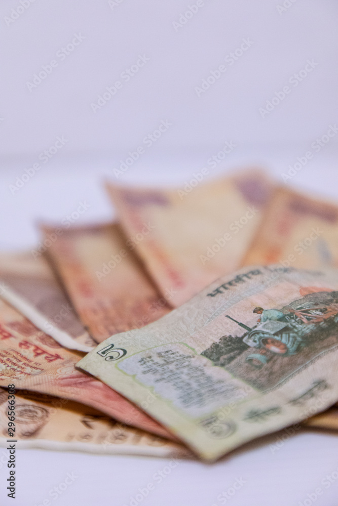 Fototapeta premium Closeup of brand new colorful Indian currency bank notes of 5 and 10, 20 rupees - white background with space for text