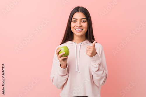 young south-asian holding an apple