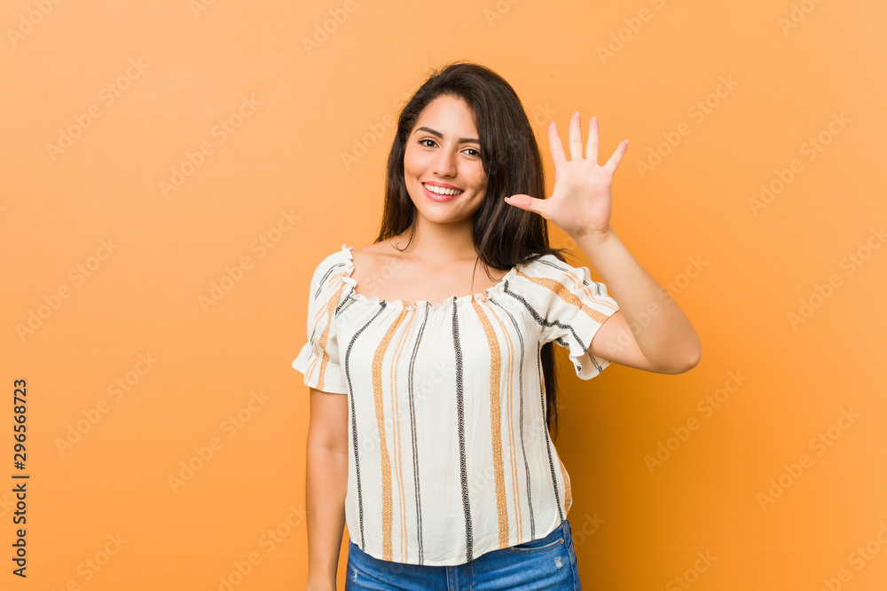 Young curvy woman smiling cheerful showing number five with fingers. Young curvy woman smiling cheerful showing number five with fingers.