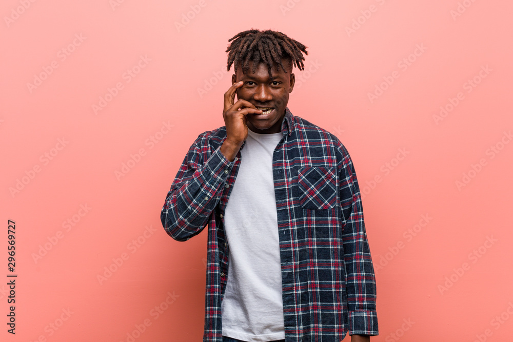 Obraz premium Young african black man biting fingernails, nervous and very anxious.
