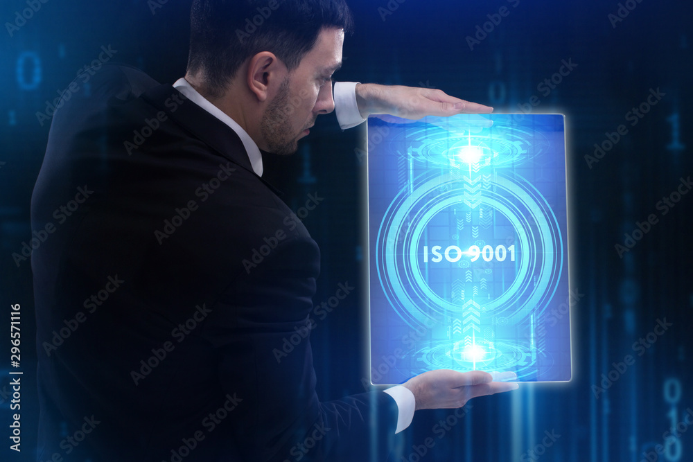 The concept of business, technology, the Internet and the network. A young entrepreneur working on a virtual screen of the future and sees the inscription: ISO 9001 The concept of business, technology, the Internet and the network. A young entrepreneur working on a virtual screen of the future and sees the inscription: ISO 9001