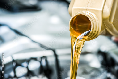 Pour motor oil to car engine. Fresh yellow liquid change with back light. Maintenance or service vehicle concept.