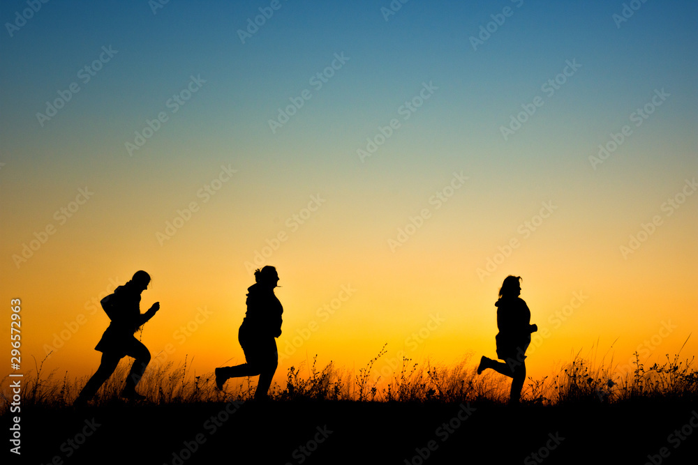 Women silhouette running at sunset