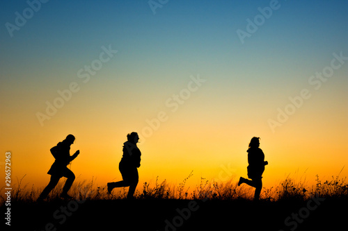 Women silhouette running at sunset