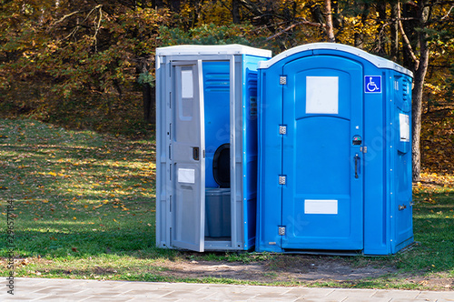 Two portable toilets in a park