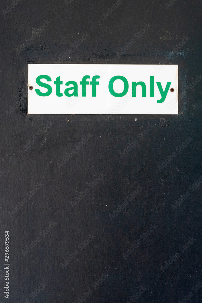 STAFF ONLY signage on a wooden door, black background, vertical layout ...