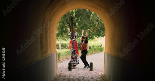 Man and woman dancing flamenco in park. Spanish people and traditional dance in Andalusia, Spain. Dancers performing traditional show in park. Couple and music arts