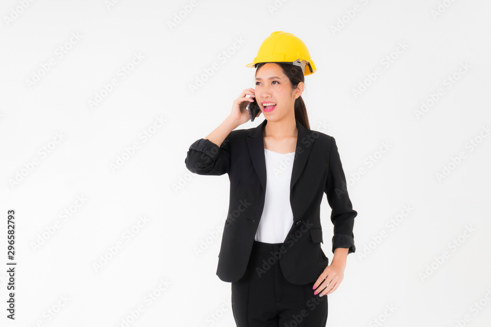 Portrait smiling Asian young engineer woman wearing a black suit black long hair and Yellow Safety helmet standing with mobile phone copy space isolated on white background studio Portrait smiling Asian young engineer woman wearing a black suit black long hair and Yellow Safety helmet standing with mobile phone copy space isolated on white background studio