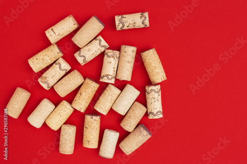 Minimal trendy concept with corks from wine bottles on red paper background with copy space. Flat lay for wine bar, winery, restaurant, wine list. photo