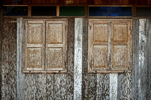 The wooden windows and wooden walls of the old house in the tropical forest. photo