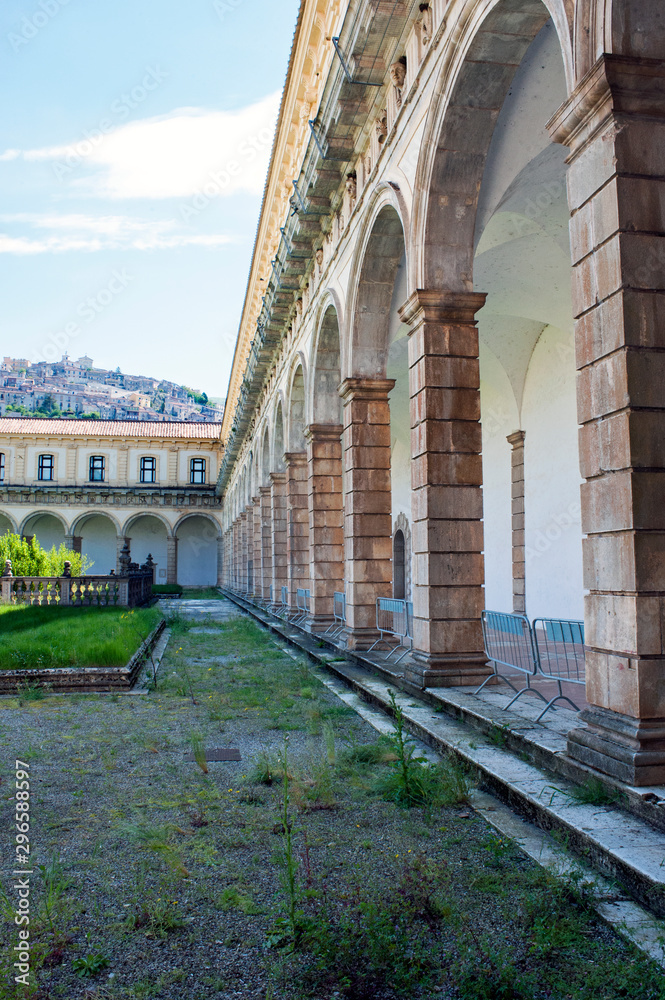 One of the cloisters of Padula Charterhouse with Padula hamlet in the background, Salerno, Italy