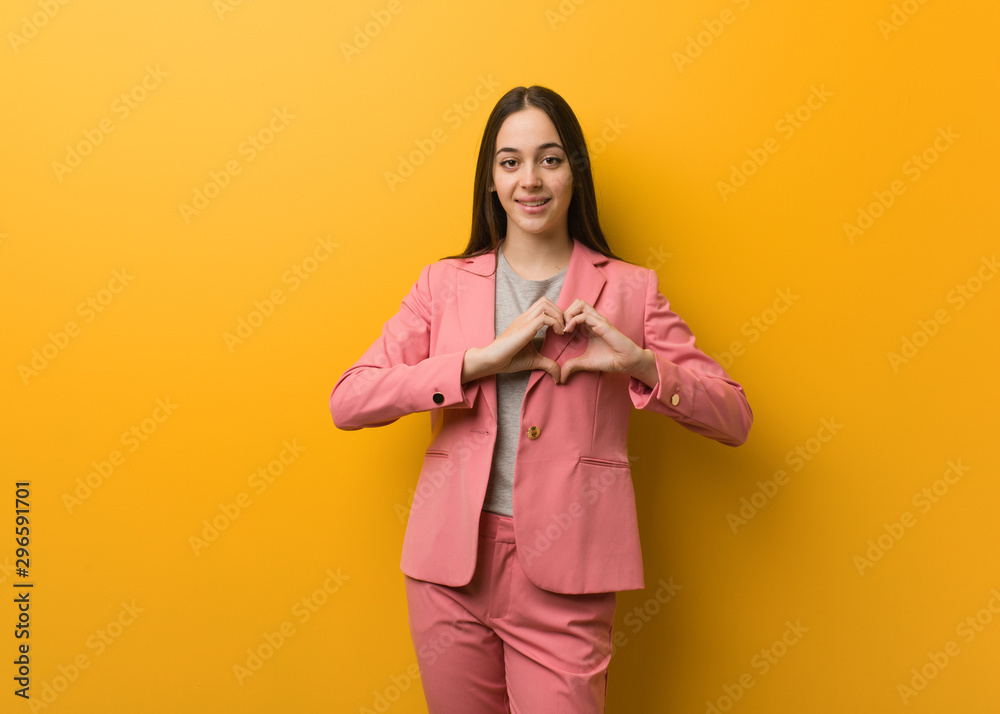 Young modern business woman doing a heart shape with hands