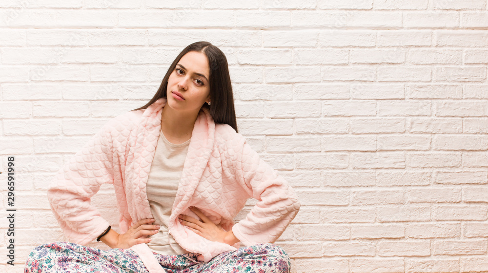 Young woman wearing pajama scolding someone very angry