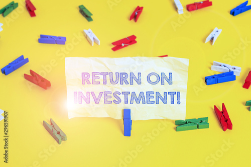 Writing note showing Return On Investment. Business concept for perforanalysisce measure used evaluate efficiency of investment Colored clothespin papers empty reminder yellow floor background office photo