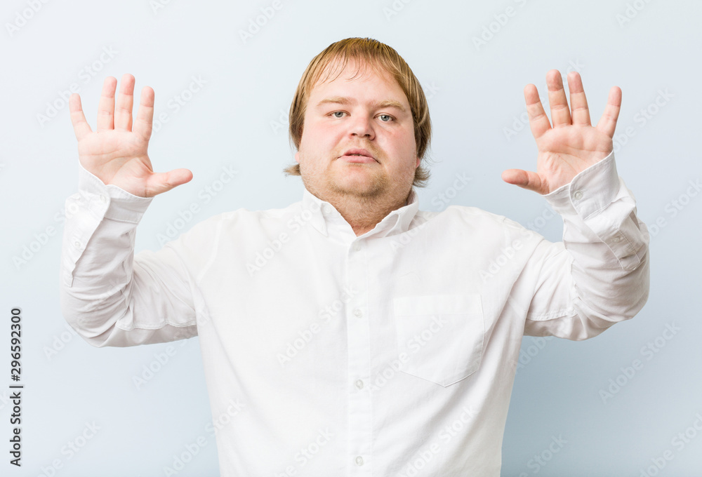 Young authentic redhead fat man showing number ten with hands.