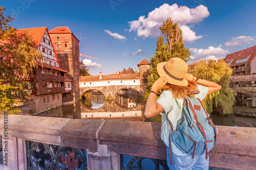 Happy asian woman tourist enjoying sunset view of the old town of Nurnberg city and Pegnitz river. Travel and student lifestyle in Germany photo