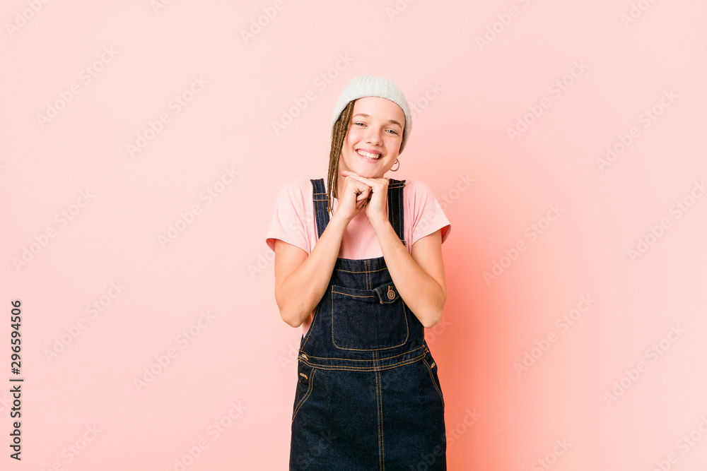 Hispter teenager woman keeps hands under chin, is looking happily aside. Hispter teenager woman keeps hands under chin, is looking happily aside.
