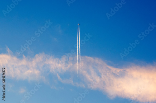 Fototapeta Naklejka Na Ścianę i Meble -  The plane flies up leaving a trail in the blue sky