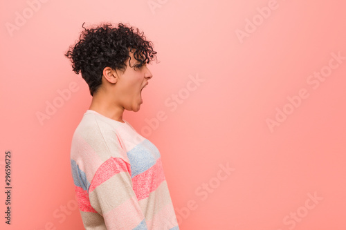 Quadro em tela Young mixed african american teenager woman shouting towards a copy space