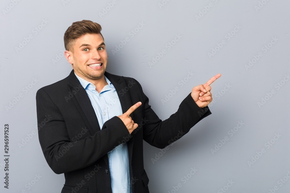 Young handsome caucasian man shocked pointing with index fingers to a copy space. Young handsome caucasian man shocked pointing with index fingers to a copy space.