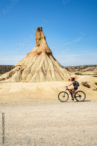 Woman rides on wonderful mountain biking trails in Bardenas Reales. Natural Park. Biosphere Reserve by UNESCO