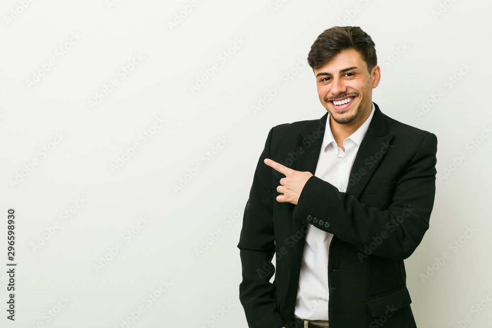 Young business hispanic man smiling and pointing aside, showing something at blank space. Young business hispanic man smiling and pointing aside, showing something at blank space.