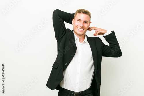 Young caucasian business man stretching arms, relaxed position.