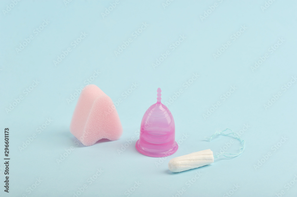 Soft tampon for playing sports on critical days, the menstrual cup and tampons are classic. Reliable protection of a new generation for modern women. Blue background. Soft tampon for playing sports on critical days, the menstrual cup and tampons are classic. Reliable protection of a new generation for modern women. Blue background.