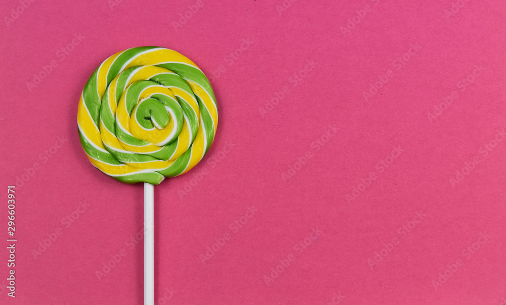 Yellow green spiral lollipop stock images. Colorful round lollipop on a pink background. Candy on a pink background with copy space for text Yellow green spiral lollipop stock images. Colorful round lollipop on a pink background. Candy on a pink background with copy space for text