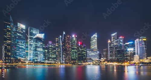Blured background cityscape at night many tower near lake marsh, swamp at Singapore. © sutlafk