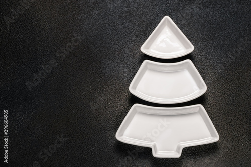Empty christmas tree shaped plate on dark background. Top view.