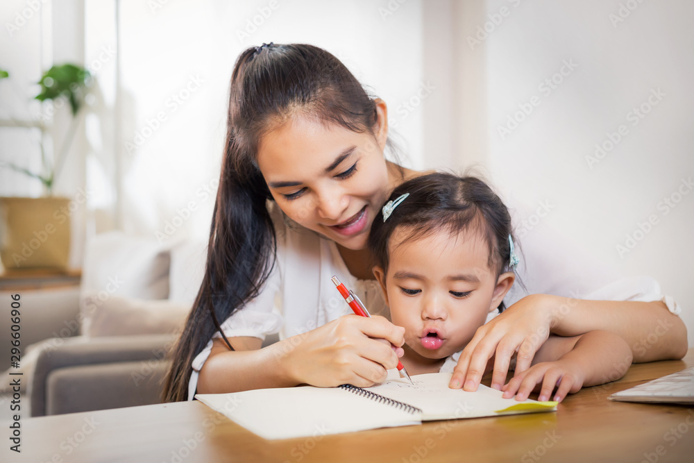 Young Asian beautiful mom with her dougther kid work at home. Young Asian beautiful mom with her dougther kid work at home.