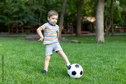 little boy playing football soccer on the field