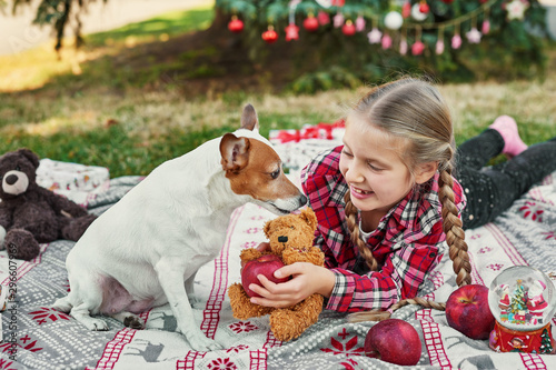 Family Christmas in July. Portrait of girl near christmas tree with dog. Baby decorating pine. Winter holidays and people concept. Merry Christmas and Happy Holidays Greeting card. Christmas child.  