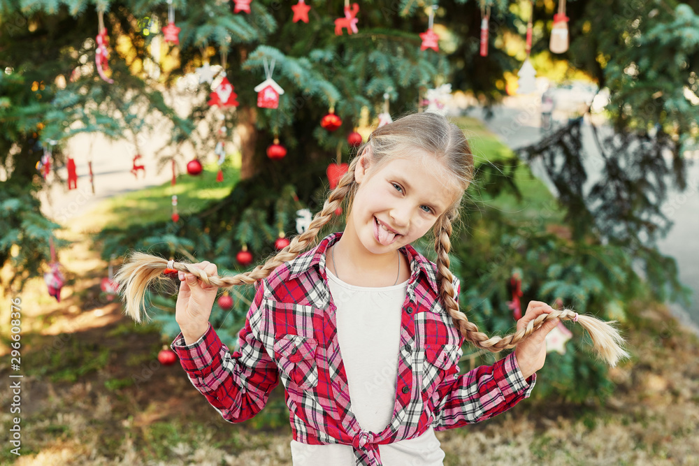 Family Christmas in July. Portrait of girl near christmas tree. Baby decorating pine. Winter holidays and people concept. Merry Christmas and Happy Holidays Greeting card. Christmas child