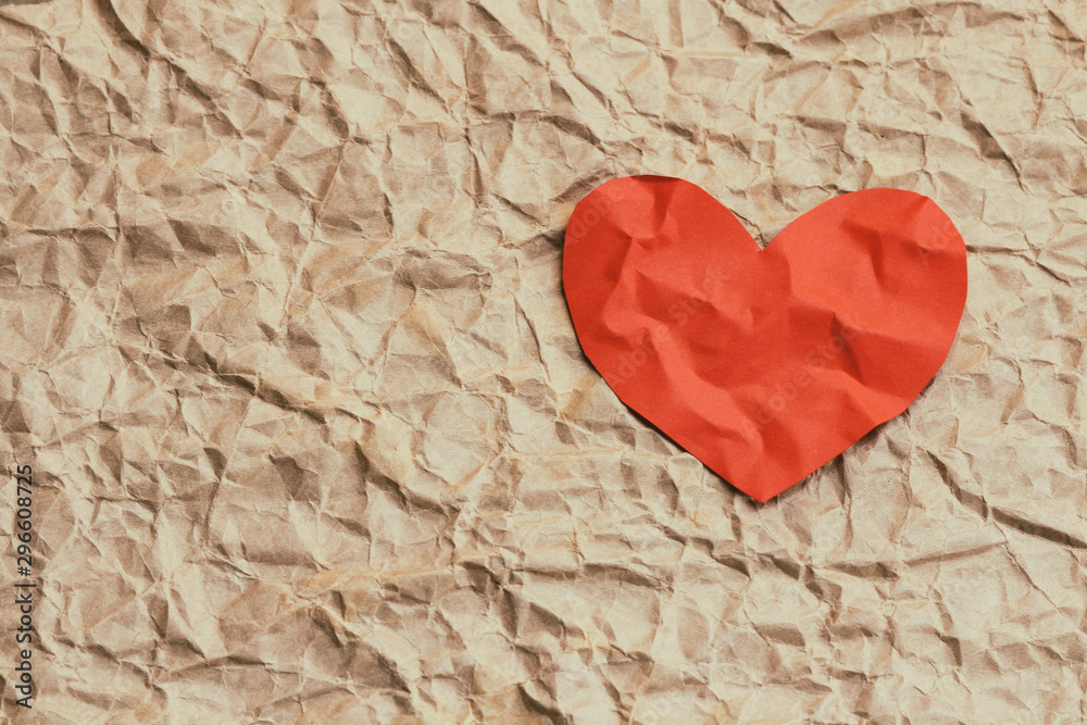 Paper red heart on crumpled craft paper. Background textures. Love. Postcard. Health insurance. Heart function test. Your text space. Paper red heart on crumpled craft paper. Background textures. Love. Postcard. Health insurance. Heart function test. Your text space.