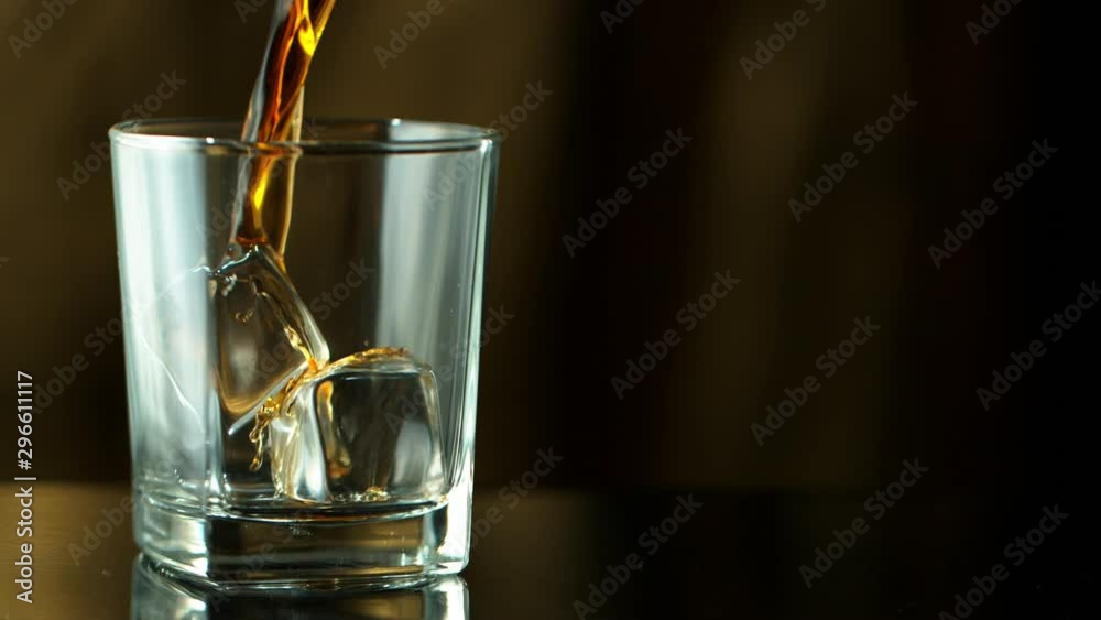 Super slow motion of pouring whiskey into glass. Filmed on high speed cinema camera, 1000fps Super slow motion of pouring whiskey into glass. Filmed on high speed cinema camera, 1000fps