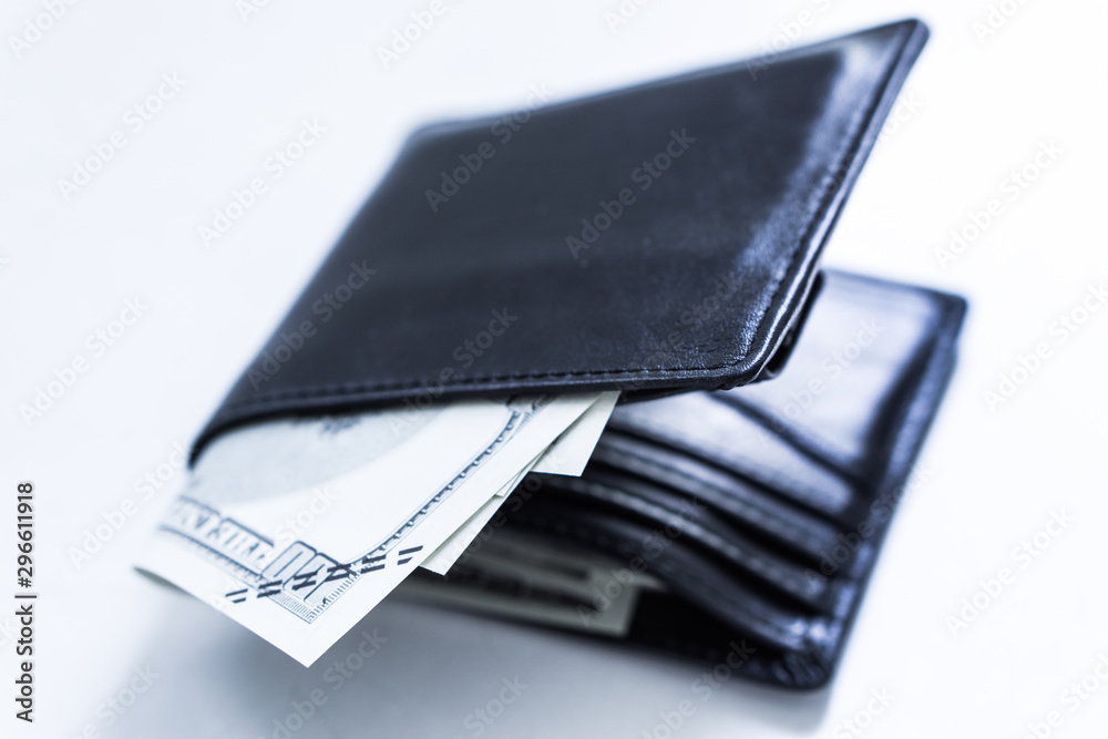 A black leather wallet with money inside on the white table. Money concept, copy space for text. A black leather wallet with money inside on the white table. Money concept, copy space for text.