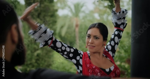 Man and woman dancing flamenco in park. Spanish people and traditional dance in Andalusia, Spain. Dancers performing traditional show in park. Couple and music arts photo