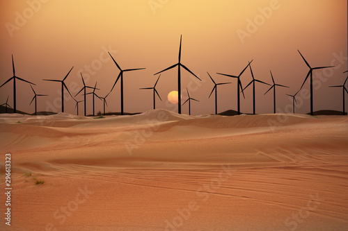 Fototapeta Naklejka Na Ścianę i Meble -  Wind turbines in the desert suggesting renewable energy concept with sand dunes at sunset
