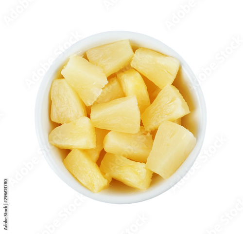 Bowl with pieces of delicious sweet canned pineapple on white background, top view